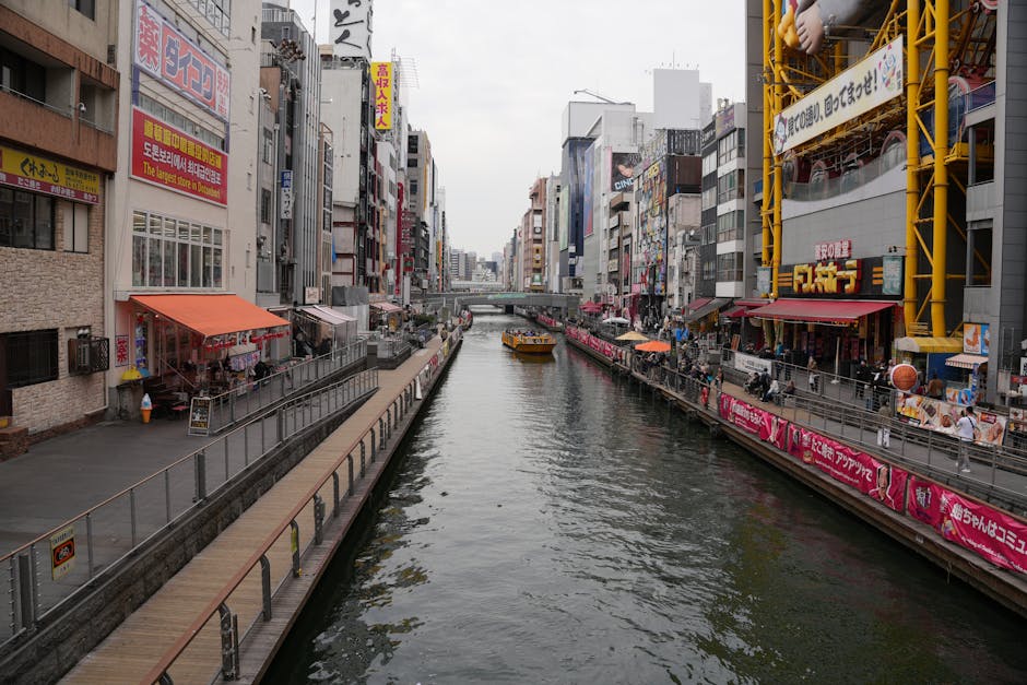 Bustling view of the iconic Dotonbori Canal lined with shops and vibrant signs in Osaka, Japan.
