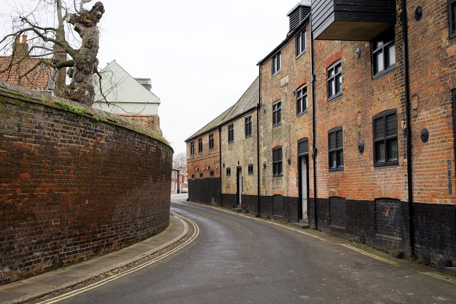 Quiet urban street in King's Lynn with historic brick buildings and curved walls.