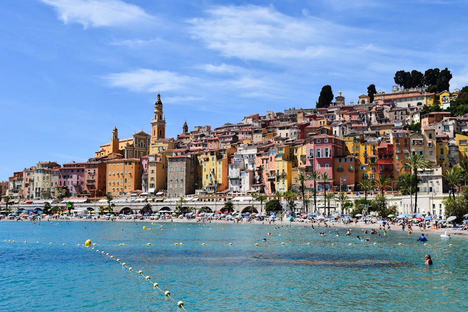 Vibrant beachfront scene in Menton, showcasing colorful buildings and lively summer activities.