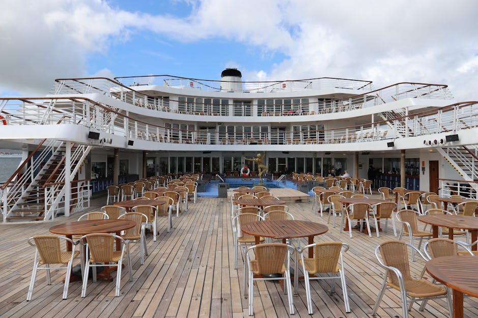 Empty cruise ship deck with tables and chairs, ideal for leisure travel.