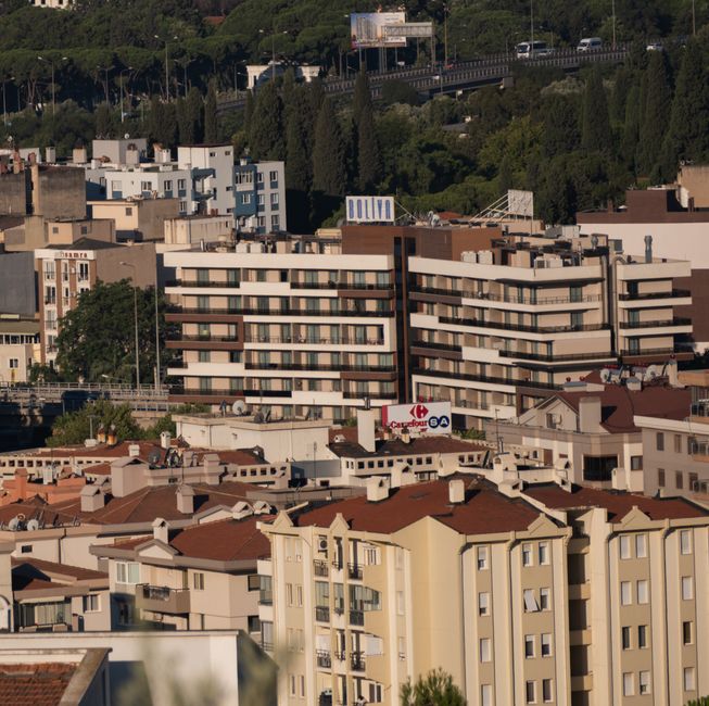 Aerial view of residential and commercial buildings in İzmir, Türkiye, surrounded by lush greenery.