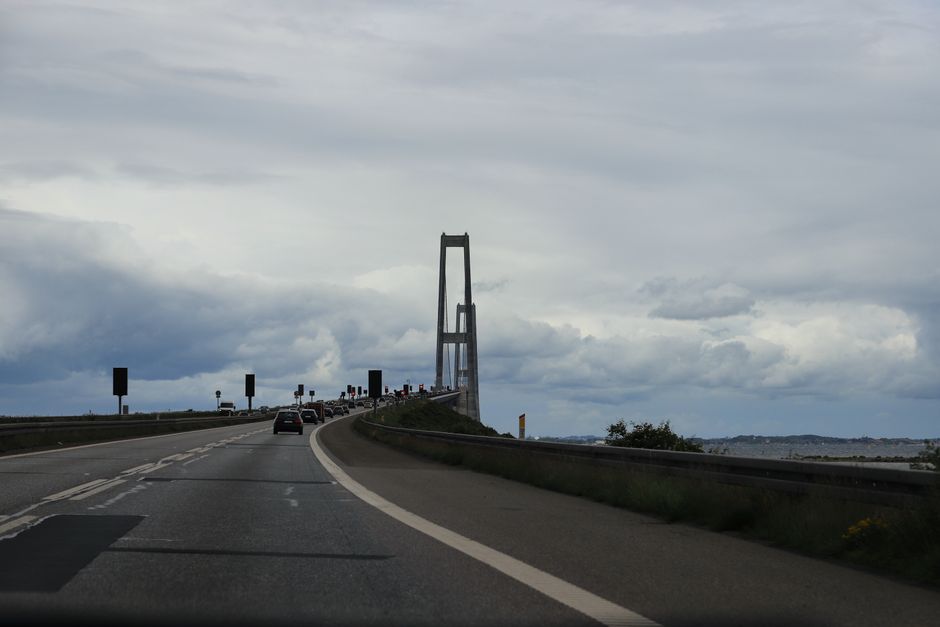 Driving towards the Great Belt Bridge in Denmark on a cloudy day, showcasing its majestic structure.