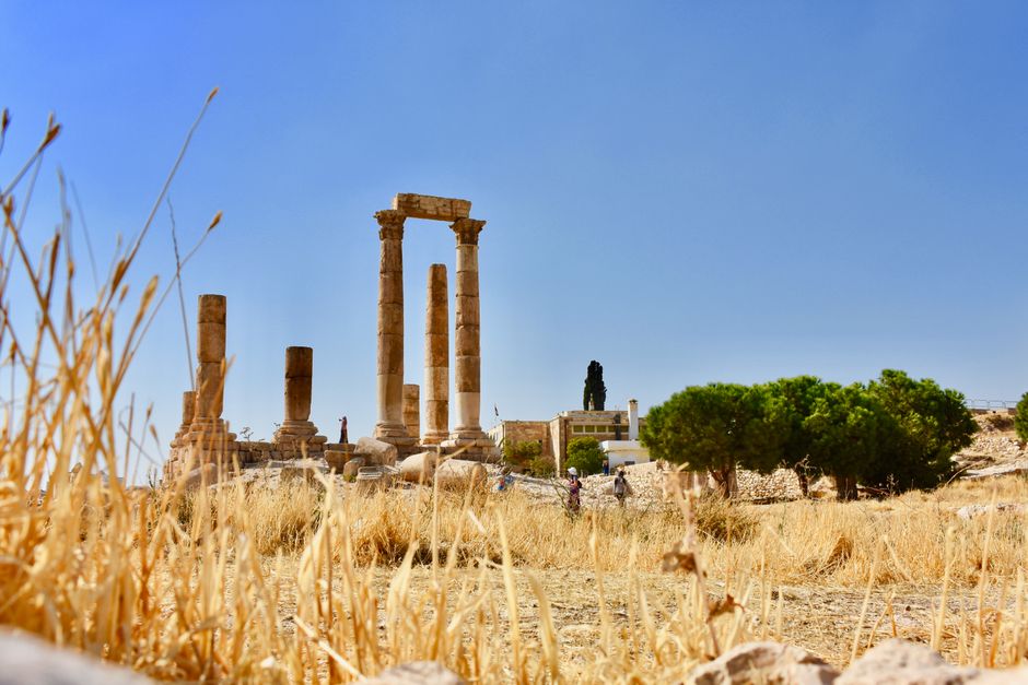 Historic Roman ruins at the Temple of Hercules in Amman with iconic stone columns under clear blue sky.