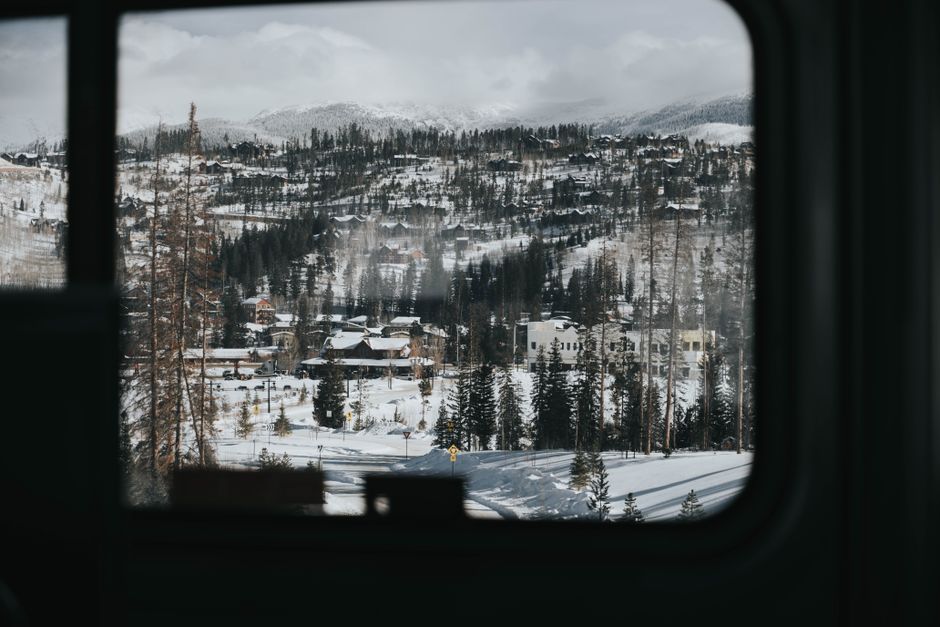 Beautiful snow-covered town surrounded by mountains viewed from a winter train ride.