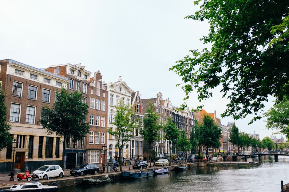 Typical Dutch architecture of cozy buildings situated on riverbank during clear spring day
