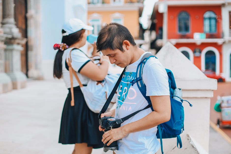 Man and woman exploring city streets with cameras, capturing vibrant urban life.