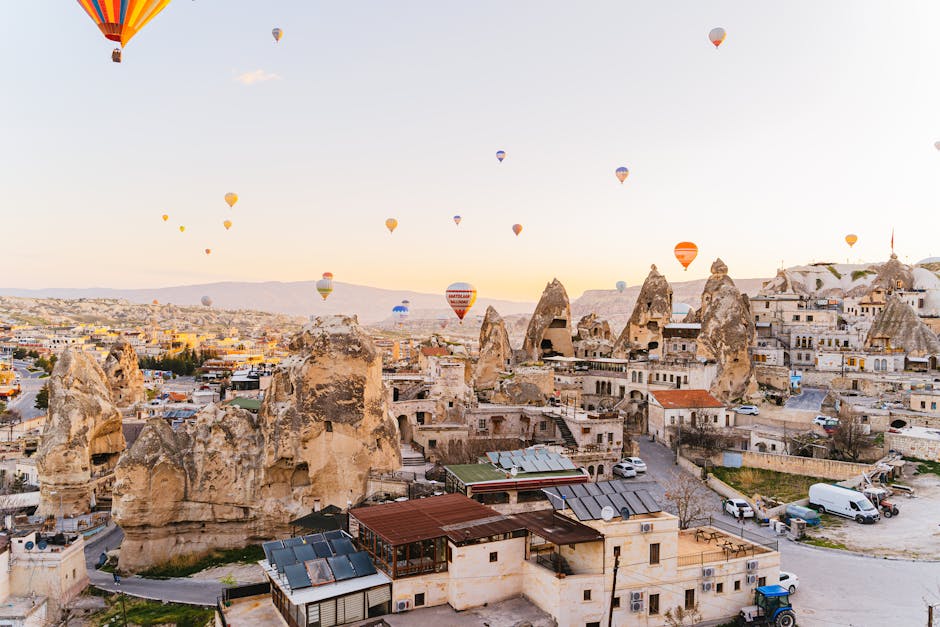 Captivating aerial view of hot air balloons over the unique Cappadocia landscape at sunrise.